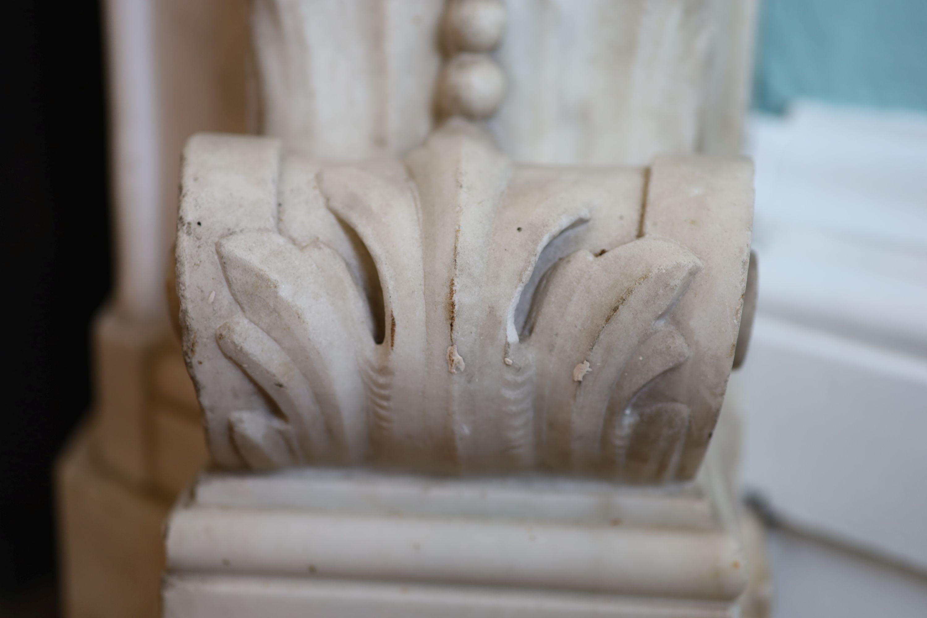 An important mid 19th century Italian white Carrara marble chimney piece, carved in the rococo taste, with seated putti, foliage swags